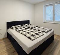 Bedroom with a double bed and a wooden decor floor in a 3-room apartment.