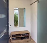 3-room apartment with a shoe bench, mirror, and wooden decor flooring.