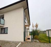 Exterior of a 3-room apartment on Kráľovianky Street in the town of Kráľovianky, with plants and a lawn at the entrance.
