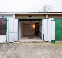 Open garage on Inovecká Street in Trenčín with interior lighting and shelves.
