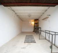 Spacious garage interior with metal shelves and white walls.
