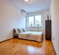 A bedroom with a bed, a floor with a wooden decor, in a 2-room apartment.