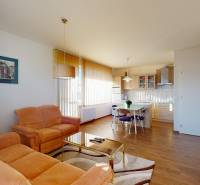 Living room with an orange sofa, table, and wooden decor flooring in a two-room apartment.