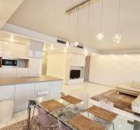 A spacious living area in a 3-room apartment with a kitchen, dining table, and comfortable sofa.