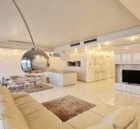 Interior of a 3-room apartment with an open kitchen and a white sofa.