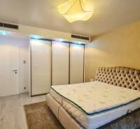 A bedroom with a comfortable bed, built-in wardrobe, and television in a 3-room apartment.