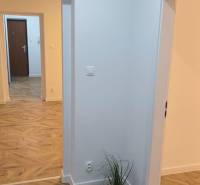 Interior of a 4-room apartment with a wood-patterned floor and white walls.