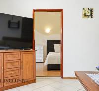 Interior of a family house with a large television, open doors to the bedroom, decorations.