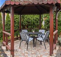 A wooden gazebo in the garden of a family house in Čierny Brod with outdoor seating.