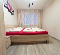 Bedroom in a two-room apartment with a bed and a floor with a wooden decor.