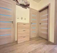 Wooden floor decor and light doors in a 2-room apartment with soft lighting.
