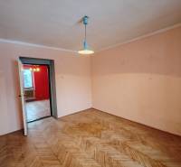 A room in a 2-room apartment with a wooden decor floor and simple lighting.