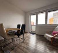Dining area with a table and chairs in a 3-room apartment, floor with wooden decor.