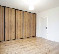 A room in a family house with a wooden decor floor and a wardrobe.