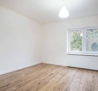 A room in a family house with electrical outlets and a floor with a wooden decor.
