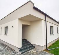 A family house in Branovo with a white facade and a paved walkway at the entrance steps.