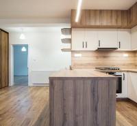 A kitchen in a family house with a wooden decor floor and wooden cabinets.