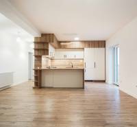 A kitchen in a family house with a wood-patterned floor and white cabinets.