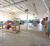 Interior of a building with a large hall, work desks, and shelves.