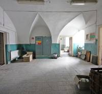 The interior of a building with a vaulted ceiling and a gray tiled floor.
