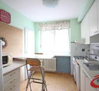 Kitchen in a 3-room apartment, with a gas stove, dining table, and appliances.