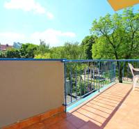 Balcony of a 3-room apartment with a view of greenery and a children's playground.
