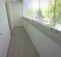 Glazed loggia with terracotta tiles, blinds, and a view, suitable for a 3-room apartment.