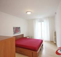 A bedroom in a 3-room apartment with a bed and a wooden decor floor.