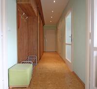 Entrance hallway in a 3-room apartment with wooden decor furniture and green seating.