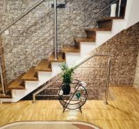 A staircase in a family house with a stone wall and a wooden decor floor.