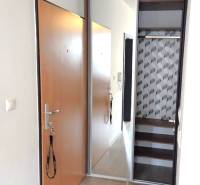 A hallway in a one-room apartment with sliding doors and a built-in wardrobe.