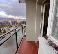Balcony of a 2-room apartment in Žilina with ceramic tiles and a view of the surrounding buildings.