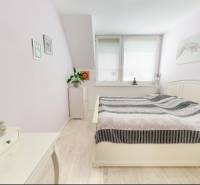 A bedroom in a family house with wood floor decor and light-colored furniture.