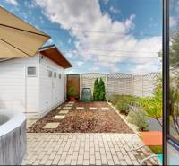 A garden of a family house in Stupava with a hot tub and a garden house.