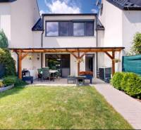 Garden and terrace at a family house in Stupava with a manicured lawn and flowerbed.