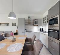Interior of a family house with a kitchen, dining table, and living room.