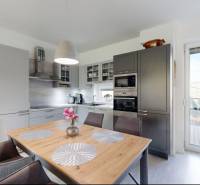 A kitchen in a family house with a dining table and access to the terrace.