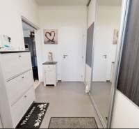 Interior of a family house with white furniture and a mirrored wardrobe. Stamp and logo on the image.