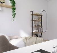 A workspace with a desk, shelves, and a bed in a 3-room apartment.