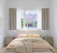 A bedroom in a three-room apartment with a bed and curtains, a plant, and pictures on the wall.