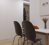 A bright dining room with dark chairs and a table, and a wooden-patterned floor.