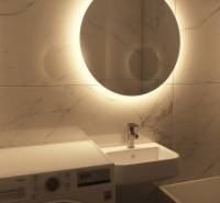 A bathroom in a 3-room apartment with light tiles and a washing machine.