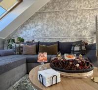 Living room in a two-room apartment with decorative pillows on the sofa and candles on the table.