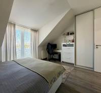 Bedroom in a two-room apartment with a desk and a wooden decor floor.