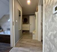 Bathroom in a two-room apartment with a wooden decor floor and light walls.