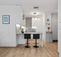 A kitchen in a 3-room apartment with a bar counter and a floor with a wooden decor.