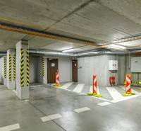 Underground garage with a parking space, warning signs, and fire extinguishers.