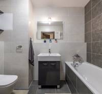 Bathroom in a 3-room apartment with a bathtub, a cabinet under the sink, and a washing machine.