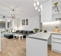 Living room with kitchen in a three-room apartment, wooden decor flooring, large sofa.