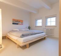 Bedroom of a 3-room apartment with a bed, lamp, and picture on the wall.